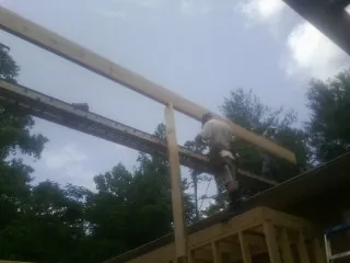 Carpenter setting a ridge beam over a new addition frame — Ice Dam Removal by Roofing Brothers in Vista