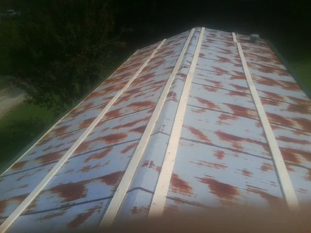 Rusted metal roof panels with new wood purlins before replacement — Storm Damage Roof Repair in Vista by Roofing Brothers