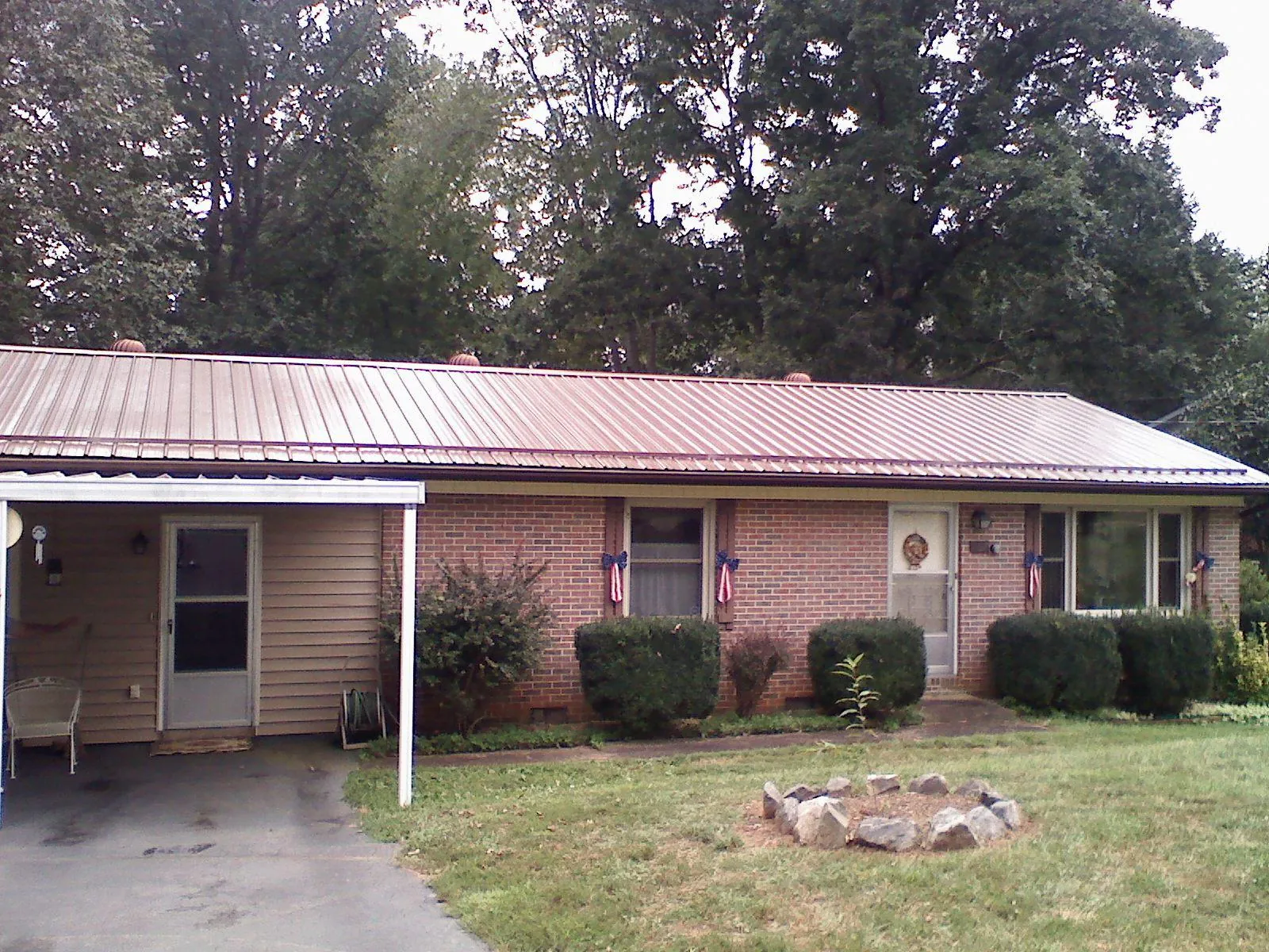 Bronze metal roof and carport on a brick ranch home — Roof Repair work by our crew in Vista